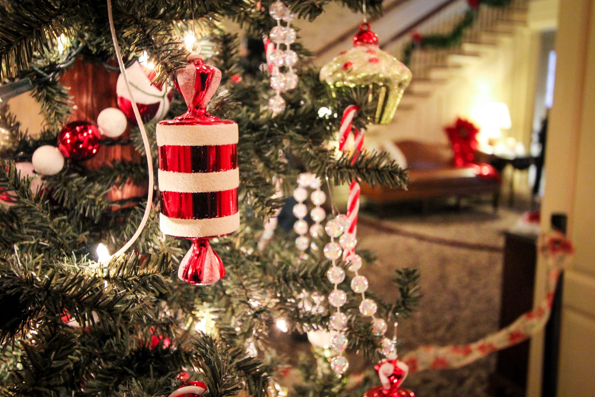 Close up of Christmas tree with vintage ornaments in a large home's entry way